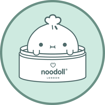 A circular mint-green graphic featuring a white cartoon dumpling character peeking out of a container with the text 'noodoll LONDON' on the front.